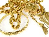 a lot of gold jewelry on a white surface