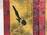 two pictures of a bird on a red and gold book