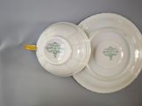 two white plates with green designs on them
