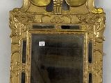 miroir avec un cadre doré et un motif floral sur le devant