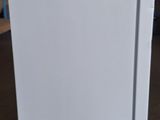 a white refrigerator sitting on the floor in a room