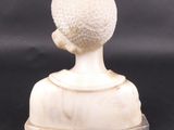marble bust of a woman with a hat on her head