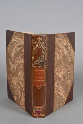 un vieux livre à la couverture brune posé sur une table