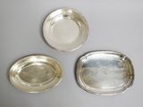 three silver trays on a table with one empty and one empty