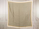 a beige and yellow blanket hanging on a clothes line