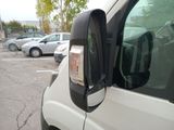 a white van parked in a parking lot with other cars in the background
