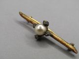 une broche en perles et en or montée sur une tige