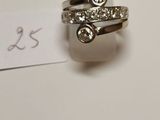 une bague en argent sertie d'un diamant, à côté d'un bout de papier sur lequel figure une étiquette de prix