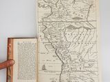 an open book with a map of the united states on it and a hand holding an open book