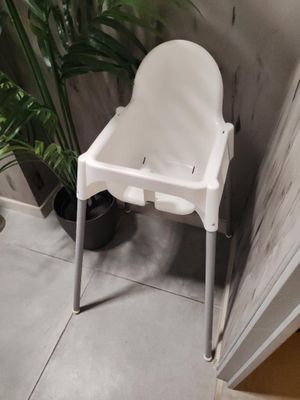 une chaise haute blanche dans un coin de la salle de bains