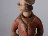a figurine of a man wearing a hat and jacket