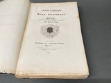 un livre ouvert posé sur une table, sur une surface grise
