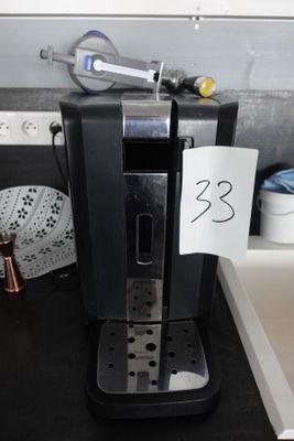 une cafetière noire posée sur le plan de travail d'une cuisine