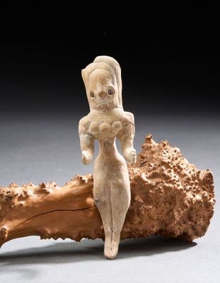 une image représentant une statue d'une femme assise sur un morceau de bois
