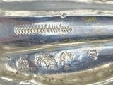 an old silver spoon sitting on top of a table next to a knife