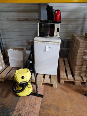 un aspirateur jaune posé sur une palette à côté d'une pile de cartons