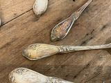 five spoons and two spoons sitting on a wooden table