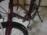 a red bike parked in a room next to a window