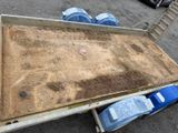 a trailer with a wooden floor and two blue bins on it