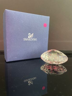 un cœur en cristal Swarooshi dans un coffret cadeau posé sur une table