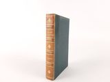 an old book sitting on top of a table next to a white wall