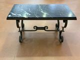une table à plateau en marbre noir montée sur roulettes, dans une pièce