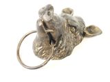 a metal animal head on a ring on a white surface