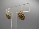 paire de boucles d'oreilles plaquées or sur un support en acrylique transparent