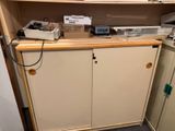une armoire sur laquelle est posée une imprimante, dans une pièce