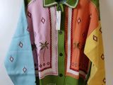 a colorful sweater hanging on a hanger on a wall