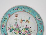 a blue plate with flowers and birds painted on it
