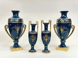 trois vases bleus avec des anses dorées, sur fond blanc