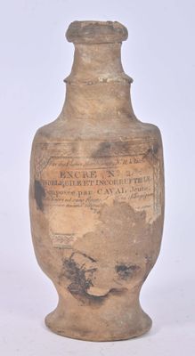 an old vase with writing on it sitting on a white surface