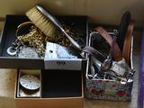 a box full of jewelry and a brush on the floor