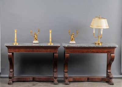pair of marble topped side tables with brass candles and a lamp