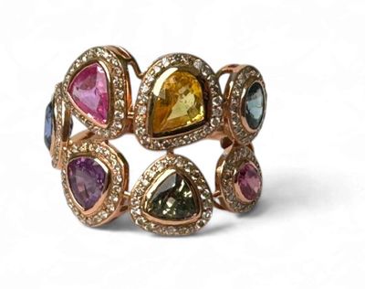 une photo en gros plan d'une bague sertie de pierres de différentes couleurs