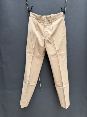 une photo d'un pantalon beige suspendu à une corde à linge