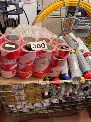 many rolls of tape in a wire basket on the floor
