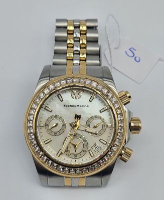 a close up of a watch on a white surface with a price tag