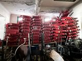 a large pile of red fire hydrants in a room