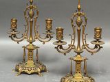 paire de chandeliers anciens en laiton avec des bougies posées sur des socles