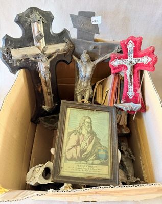 une boîte contenant une croix, un cadre photo, un crâne et d'autres objets
