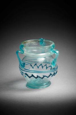 une photo d'un vase en verre muni d'une anse, posé sur une table