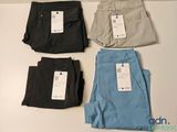 trois paires de pantalons pour homme sur lesquelles est encore accrochée l'étiquette de prix