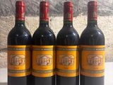 quatre bouteilles de vin sont alignées sur une table