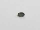 a green sapphire stone on a white surface