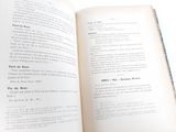 an open book on a table with a cup of coffee on it