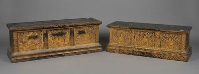 pair of carved wooden boxes with carvings on them on a gray surface