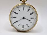 une montre de poche en or avec des chiffres romains sur le cadran