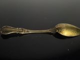 a silver spoon with a spoon handle on a black surface